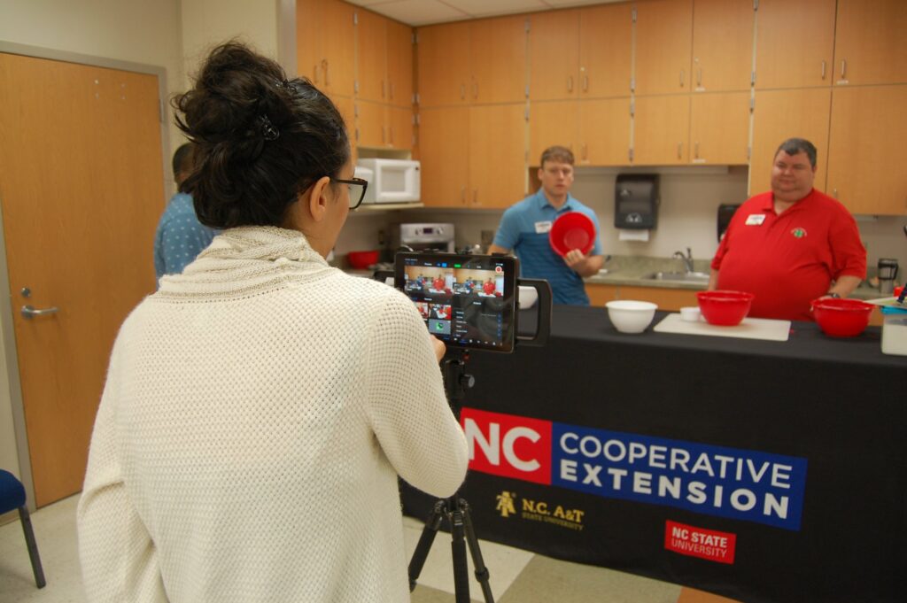 Picture of woman filming two men doing a cooking program for 4-H members